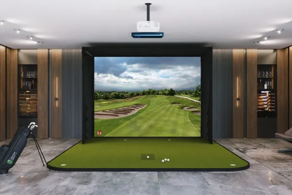 Home golf simulator setup with hitting mat, impact screen and projector